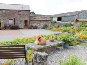 a pot sitting on a bench in a garden at Piggery Cottage in Wigton