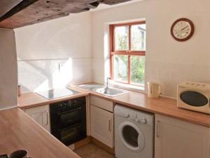 a kitchen with a sink and a microwave at Wagon House in Horton in Ribblesdale