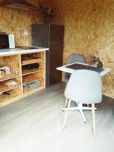 a kitchen with a table and a chair and a refrigerator at Refúgio do Valouto in Torneiro