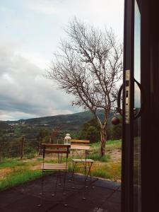 een picknicktafel en stoelen buiten een deur bij Refúgio do Valouto in Torneiro