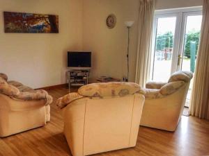 a living room with two couches and a television at Cooinda Cottage in Morar