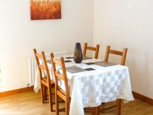 a dining room table with chairs and a vase on it at Cooinda Cottage in Morar