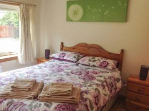 a bedroom with a bed with towels on it at Cooinda Cottage in Morar