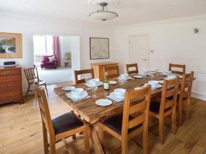 uma sala de jantar com uma mesa de madeira e cadeiras em Cringles House em Silsden