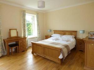 a bedroom with a large bed and a window at Cringles House in Silsden