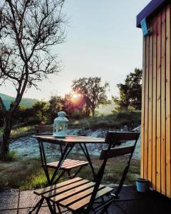 a picnic table with a lantern on top of it next to a bench at Refúgio do Valouto in Torneiro