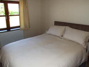 uma cama branca num quarto com uma janela em Dovetail em Oakle Street