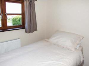 a white bed with a pillow and a window at Dovetail in Oakle Street