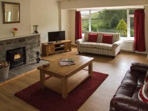 uma sala de estar com um sofá e uma lareira em Cwmgilla Farm em Knighton