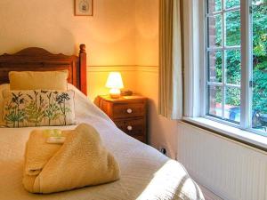 a bedroom with a bed with a towel on it at Aqueduct Cottage in Chirk