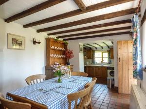 a kitchen with a table with a blue and white table cloth at Chevinside Cottage in Hazelwood