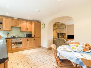 a kitchen and living room with a table and chairs at Brian's Cottage in High Buston