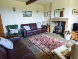 a living room with a couch and a fireplace at Street Head Farm in Cononley