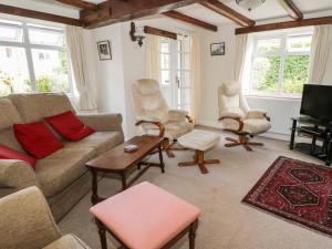 a living room with a couch and chairs and a tv at Lyndale Cottage in Robin Hood's Bay