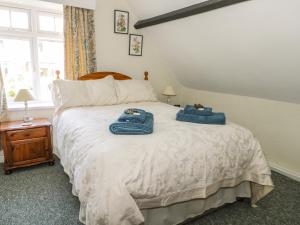 a bedroom with a bed with two blue towels on it at Lyndale Cottage in Robin Hood's Bay
