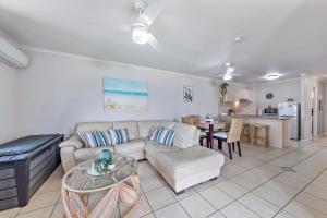 a living room with a couch and a table at Airlie Sunset Waterview Apartment in Airlie Beach