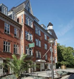 um sinal de rua em frente a um edifício de tijolos vermelhos em BB-Hotel Vejle Park em Vejle