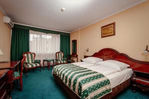 een hotelkamer met een bed, een bureau en stoelen bij Hotel Chopin in Sochaczew