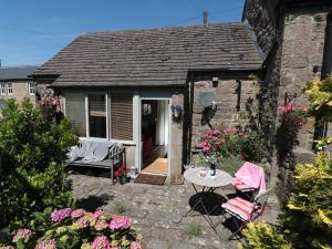 a patio with a table and chairs in front of a house at Cobbled Corner in Elton