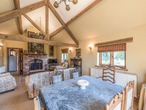ein Wohnzimmer mit einem Tisch und einem Kamin in der Unterkunft Garden Barn in Highley