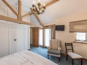 a bedroom with a bed and a chair and a tv at Garden Barn in Highley