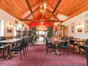 a restaurant with wooden ceilings and tables and chairs at Prince Cottage in Loftus