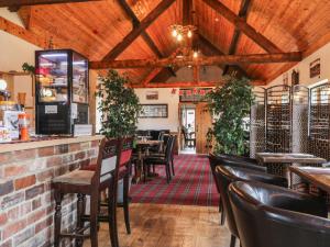 a restaurant with wooden ceilings and tables and chairs at Prince Cottage in Loftus