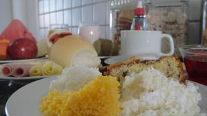 a white plate with a piece of cake on a table at Hotel Pousada Executiva Itabuna in Itabuna