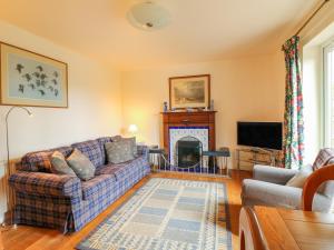 a living room with a couch and a fireplace at Barks Cottage in Whiston