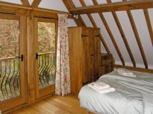 a bedroom with a bed and a large window at Hiraeth in Penybont