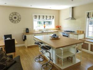 a kitchen with a table and two bar stools at White Gables in Great Clifton