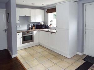 a kitchen with white cabinets and a tile floor at Alveton in Alton