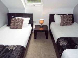 a room with two beds and a table with a lamp at Alveton in Alton