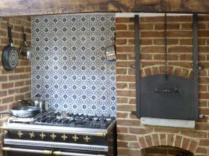 a kitchen with a stove and a brick wall at The Sun House in Ferrensby