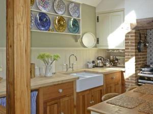 a kitchen with a sink and plates on the wall at The Sun House in Ferrensby