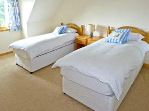 two twin beds in a room with at Bruach Gorm Cottage in Grantown on Spey