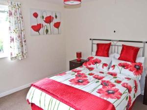um quarto com uma cama com almofadas vermelhas em Matlock Green em Matlock