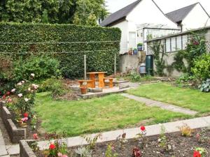 マトロックにあるMatlock Greenの庭に木製テーブルがある庭園