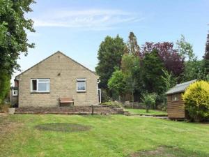 a brick house with a bench in a yard at Matlock Green in Matlock