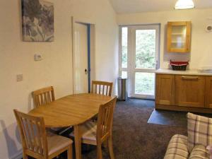 uma sala de estar com uma mesa de madeira e uma cozinha em Hendre Aled Cottage 1 em Llansannan