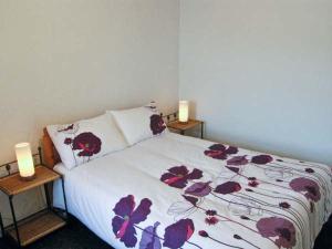 a bedroom with a bed with purple flowers on it at Hendre Aled Cottage 1 in Llansannan