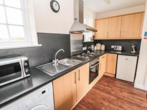 a kitchen with a sink and a microwave at No 3 Low Hall Cottages in Scalby