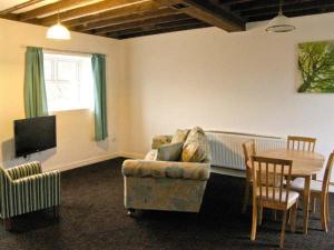 a living room with a couch and a table at Hendre Aled Cottage 3 in Llansannan