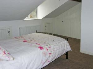 a bedroom with a bed with pink flowers on it at Hendre Aled Cottage 3 in Llansannan