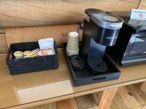 - une cafetière sur une table avec une boîte de café dans l'établissement River's Fork Lodge, à Salmon