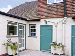 a house with a green door and two flower boxes at Brock Cottage in Beaulieu