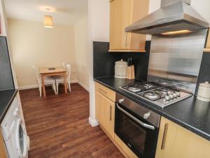 een keuken met een fornuis top oven naast een tafel bij No 2 Low Hall Cottages in Scalby +2 foto's