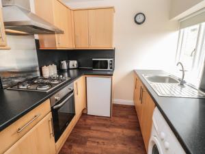 een keuken met een spoelbak en een fornuis bovenste oven bij No 2 Low Hall Cottages in Scalby