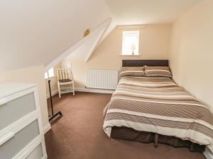 een slaapkamer met een bed en een trap bij No 2 Low Hall Cottages in Scalby