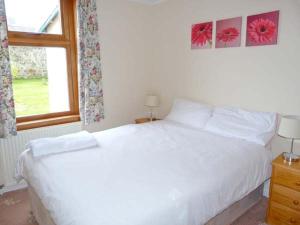 BanavieにあるLaxdale Cottageのベッドルーム(白いベッド1台、窓付)